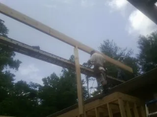 Carpenter setting a ridge beam over a new addition frame — Ice Dam Removal by Roofing Brothers in Wilmington